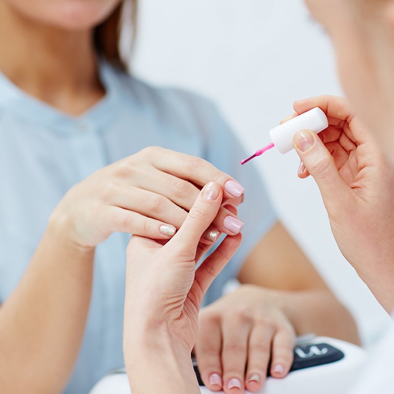 Instructor demonstrating professional nail polish application in Planet Nails Art online nail technician course Italy